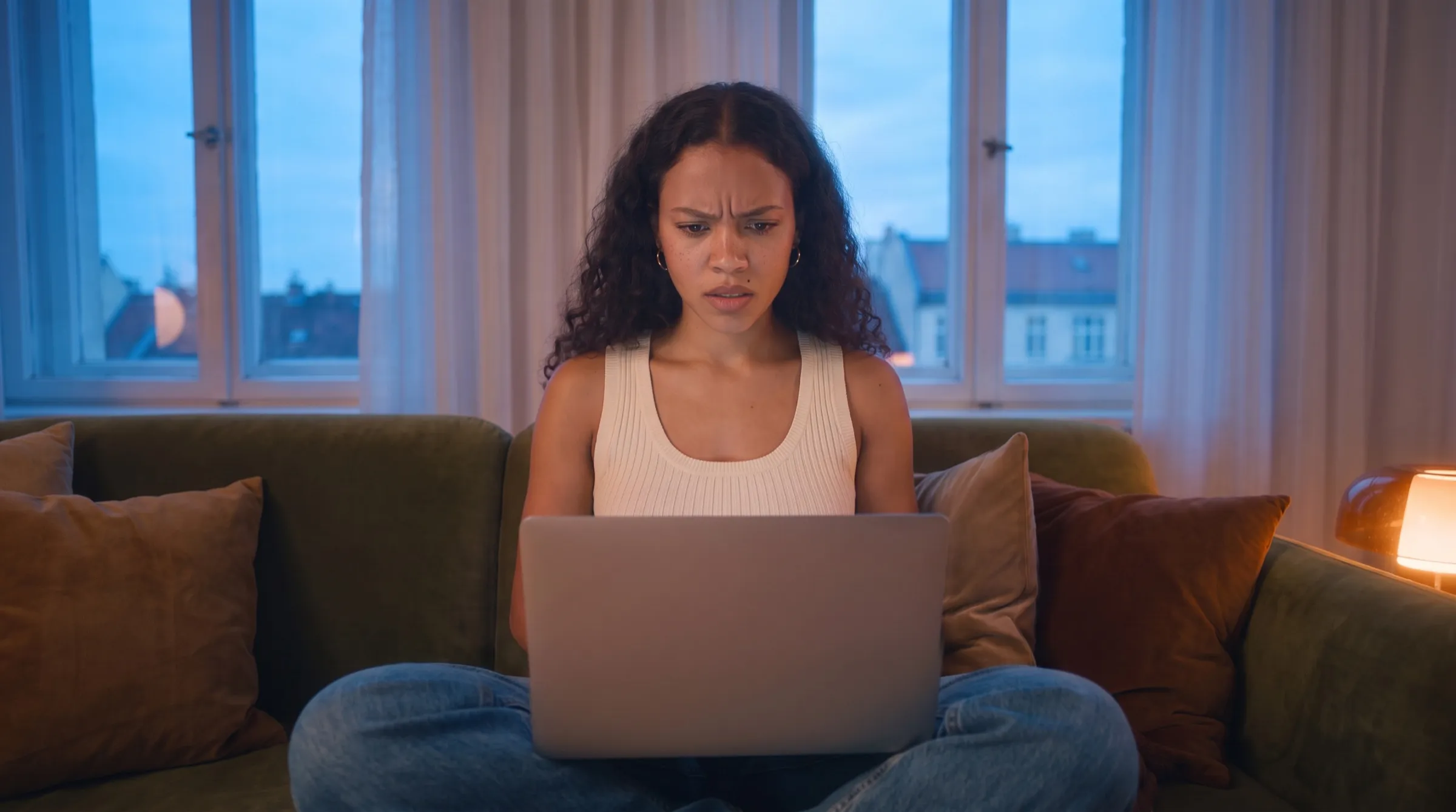 KI-Werbespot ABOUT YOU x Google: Frau auf dem Sofa, genervt vor dem Laptop